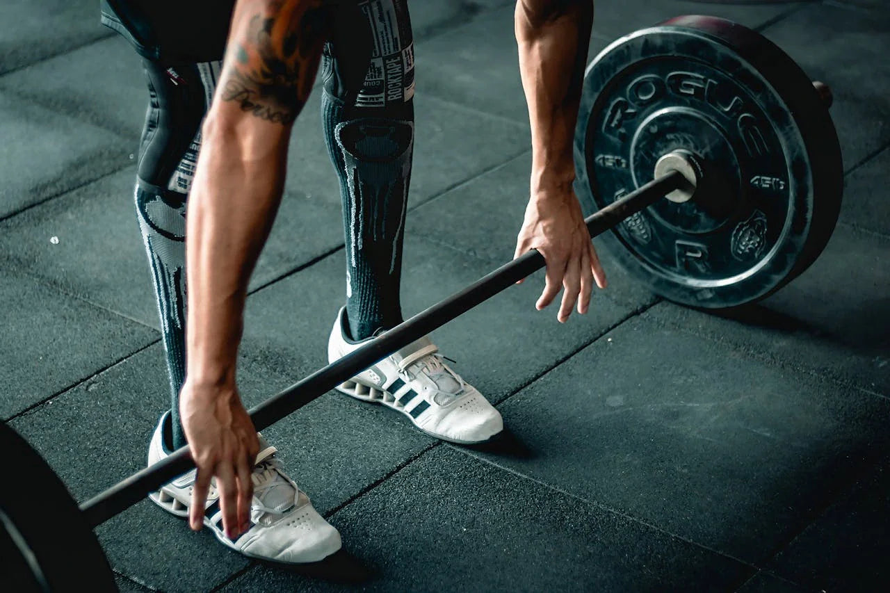 A man holding a barbell weight in the gym - Man's Health