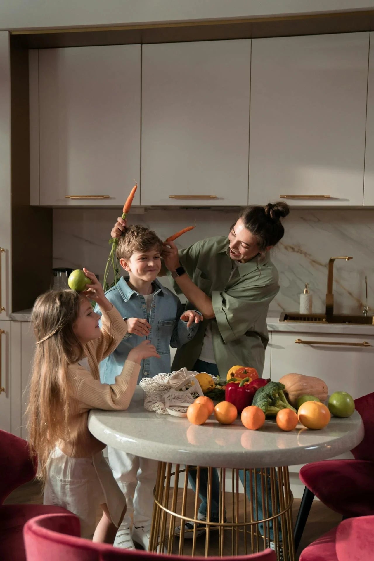 A mum and 2 children in the kitchen with fruit and vegtables