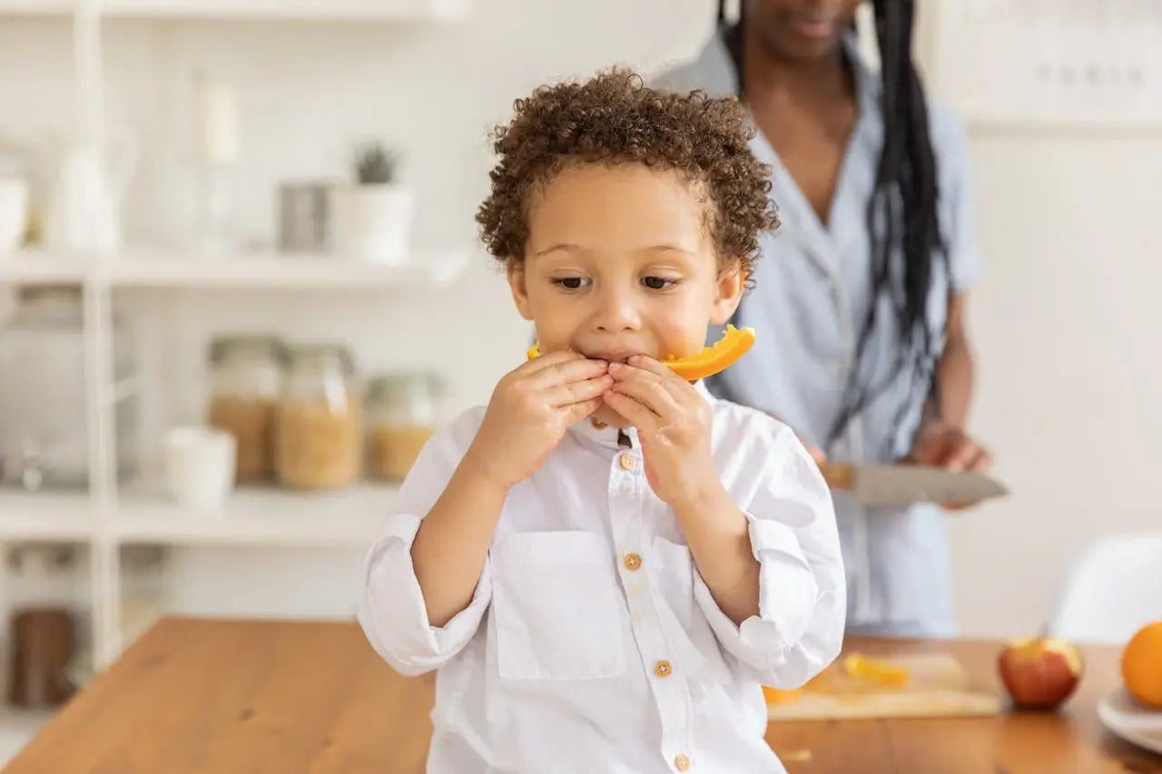 A kid eating a vitamin rich orange