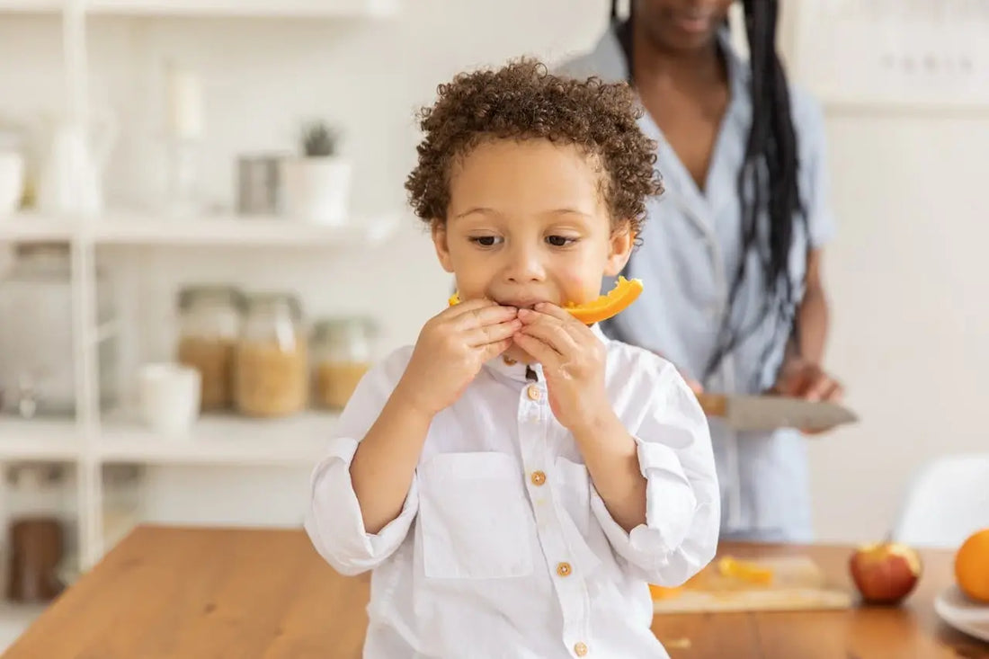 A kid eating a vitamin rich orange