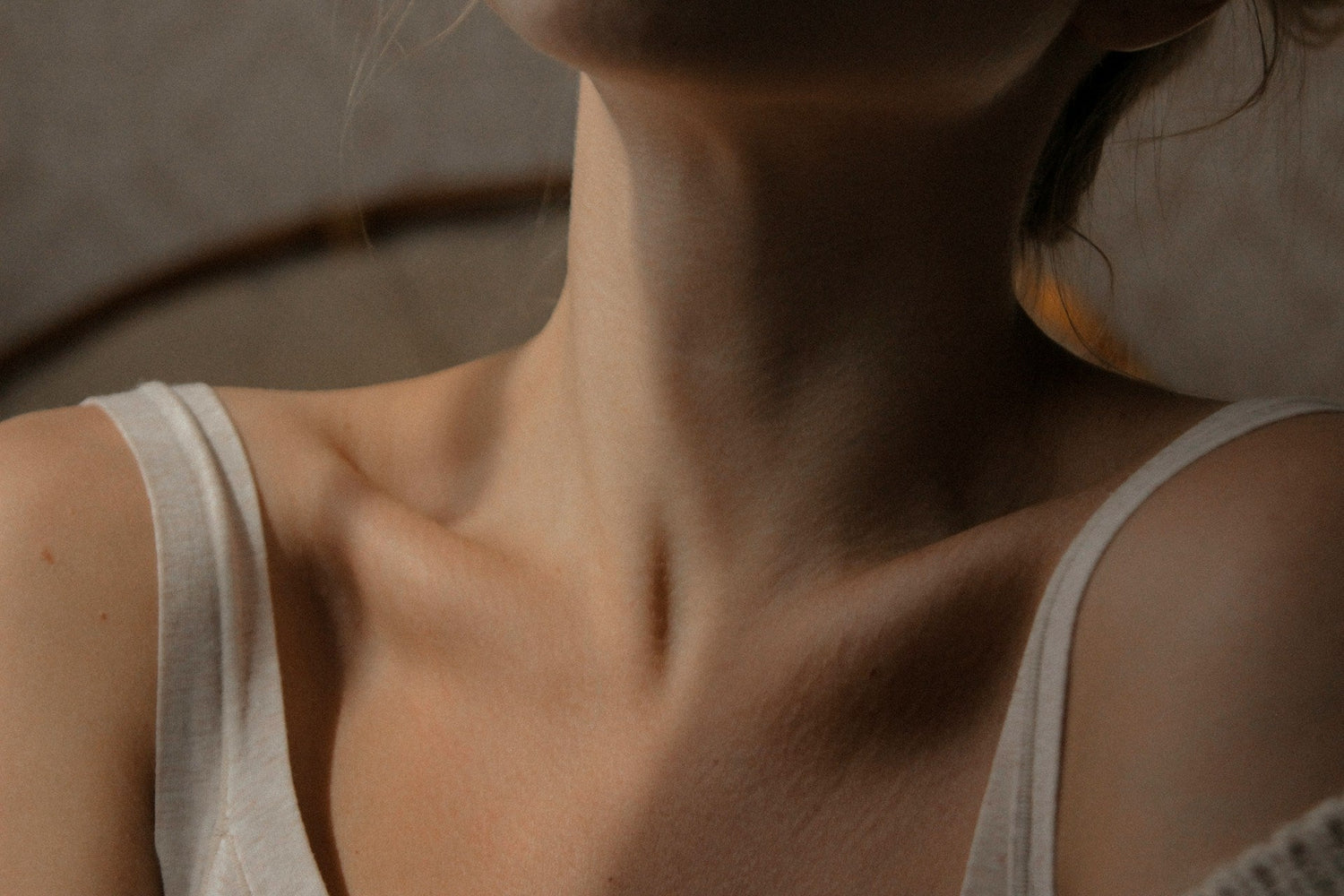Women visibly showing her thyroid with a vest
